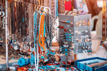 costume jewelry and beads and bracelets at the flea market are for sale.