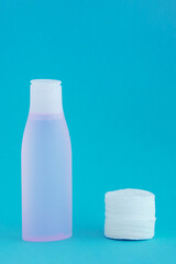 Facial lotion  cotton pads. Turquoise background.