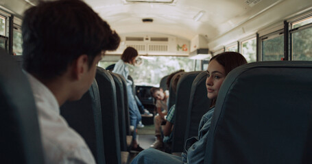 Obraz premium Multiethnic classmates chatting ride school bus. Kids wait schoolmates to board.
