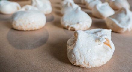 Fototapeta na wymiar Homemade french milk-colored meringues on crumpled craft paper