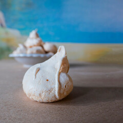 Homemade french milk-colored meringues on crumpled craft paper