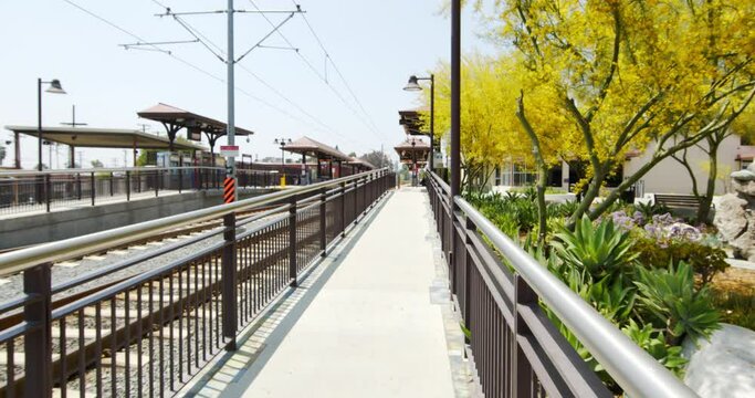 Forward Pan Of Walkway And Tracks At A Metro Train Station Depot On A Sunny Day - Los Angeles, California