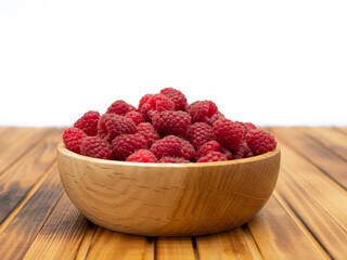 Raspberries in wooden bowl. Raspberry with copy space for text.