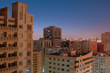 Fototapeta na wymiar Balcony view of generic apartment buildings in the residential neighborhood of Al Qasimia in Sharjah, United Arab Emirates. Urban scene at dusk.