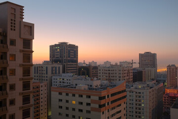 Fototapeta na wymiar Balcony view of generic apartment buildings in the residential neighborhood of Al Qasimia in Sharjah, United Arab Emirates. Urban scene at sunrise.