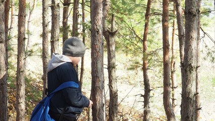 boy with a tourist backpack walks along the lake in autumn. Tourism, camping, hiking. time in nature. child hikers enjoying the view at the top of a mountain in the fall