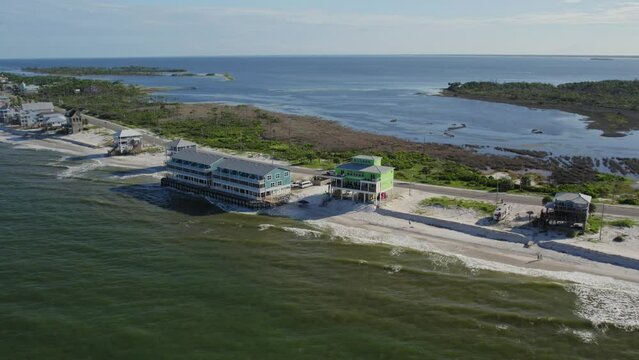 Aerial showing beach front large condominium style home at the edge of the surf - beach erosion - high tide