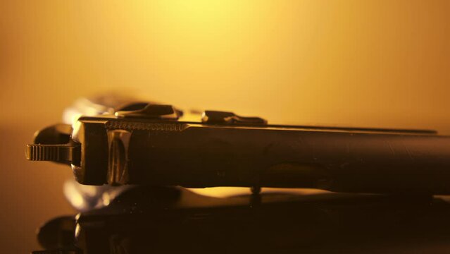 Gun Control. Studio shot of a 9mm gun rotating on a reflective surface