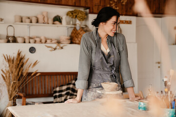 Young beautiful smiling woman leaning on table and looking aside