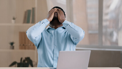 Frustrated shocked african businessman american adult man student work on computer make error...
