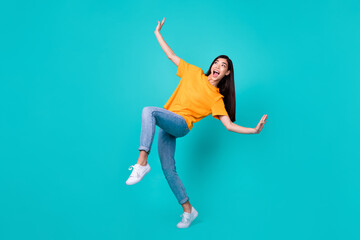 Fototapeta na wymiar Full length photo of lovely brunette lady dance look up wear t-shirt jeans shoes isolated on teal color background