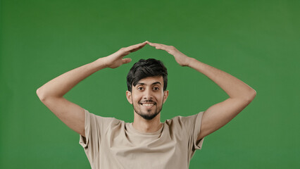 Hispanic young man arabian guy raise hands over head make house roof frame gesture with arms feel...
