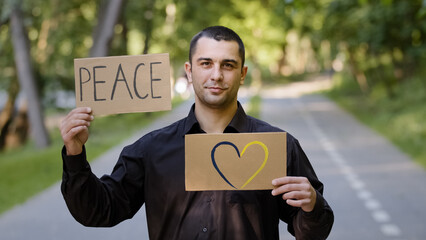 Handsome caucasian man adult businessman patriot guy stands in park outdoors holds two banners...
