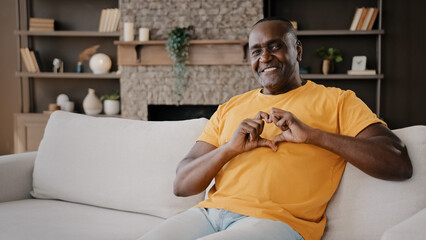 African affectionate lover man gentle american adult senior volunteer make heart shape with fingers...