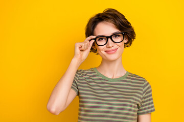 Fototapeta premium Photo of sweet adorable lady wear striped t-shirt arm spectacles smiling empty space isolated yellow color background