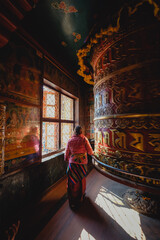 An pilgrims spinning the giant prayer wheel at Boudhanath Temple, Kathmandu, Nepal.
