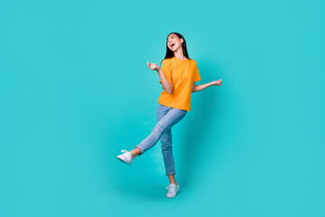 Full size photo of cool millennial lady dance wear t-shirt jeans sneakers isolated on turquoise color background