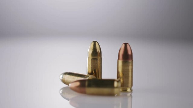 Gun Control. Ammunition of 9mm bullets rotating on a reflective surface