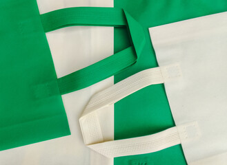 white and green non woven cloth tote bag. a composition made of non-woven textile fabrics of pastel...