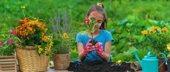 The child is planting flowers in the garden. Selective focus.