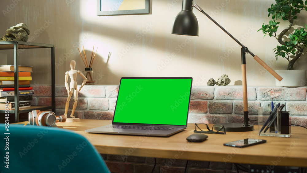 Fototapete laptop computer standing on a wooden desk with a green screen chromakey mock up display. cozy empty 