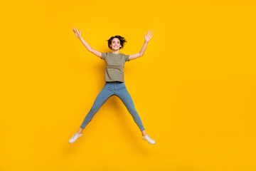 Fototapeta na wymiar Full length photo of excited charming lady wear striped t-shirt jumping high empty space isolated yellow color background