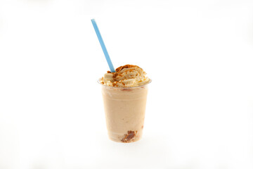 Cookie butter crumbs ice cream gelato shake with whipped cream and blue straw in a plastic cup.