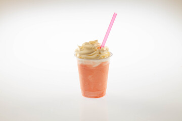 Strawberry gelato ice cream shake with whipped cream on top and straw.