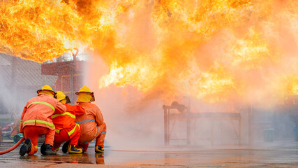 Fireman,Firefighter training Firefighters using water and fire extinguishers to fight the flames in...