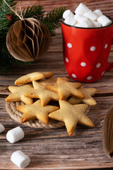 New Year's star-shaped cookies made at home, next to a red mug of marshmallow.
