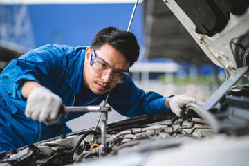 Asian mechanic in a car repair shop. mechanic in service center car safety check Repair service...