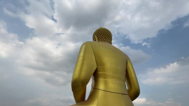 Giant golden buddha statue at Wat Paknam Phasi Charoen, famous buddhist temple with blue sky background - day. BANGKOK, THAILAND 