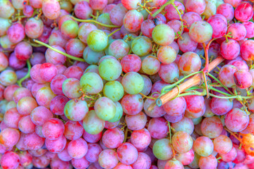 Bunches of green and red grapes on a tray agriculture market.