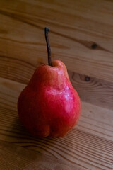 Red pear on a wooden table. Copy space