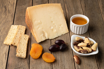 Artisanal Tulha cheese from Brazil with nuts and fruits over wooden table
