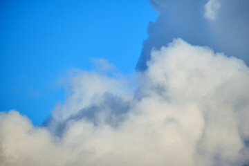 Bright landscape of white puffy cumulus clouds on blue clear sky