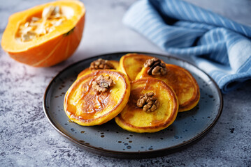 Pumpkin pancakes with walnuts and caramel sauce in a plate