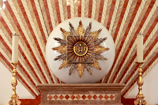 Church tabernacle with the inscription jhs jesus monogram and two candles in the church dedicated to saint Jopseh the worker in Monasterace, Calabria Italy