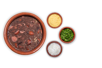 Delicious feijoada bowl with side dishes. Brazilian typical cuisine made with black beans and pork on white isolated background.