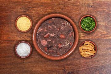 Delicious feijoada bowl with side dishes. Brazilian typical cuisine made with black beans and pork