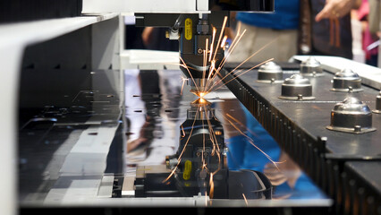 Industrial laser machine cutting metal, robotic mechanism sample at the international exhibition,...