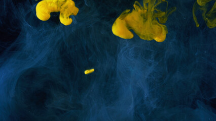 Beautiful yellow paint drops spreading in water. Stock footage. Close up of clouds of yellow and...
