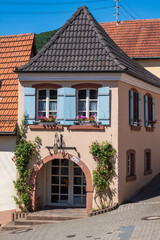 View of a house decorated with flowers with blue shutters in St. Martin/Germany