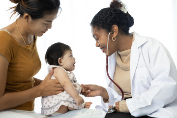 Obraz premium mother and baby visit to the doctor using stethoscope checking heart beat