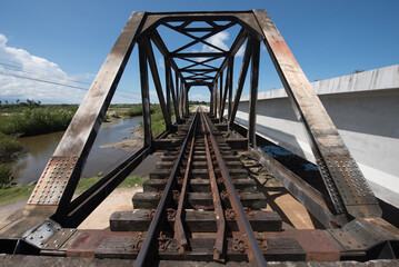 Railway is on black steel bridge.Perspective of steel bridge.