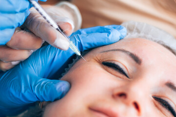 Kharkiv, Kharkiv Oblast, Ukraine - 08 18 2021: Botox injection into mimic wrinkles by a student...