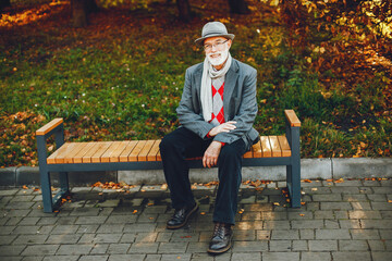 Elegant old man in a sunny autumn park