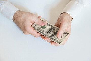 Close up of male hands hold a stack of 100 US dollar bills. Business, finance, economy concept. Top view.