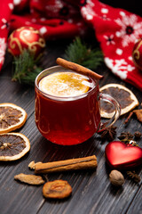 Fruity mulled wine on a wooden background with spices.