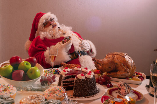 Santa Claus eating a Christmas turkey dinner.